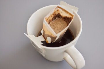 brewing process,a bag filled with boiling water for drip coffee in a cup,top view.