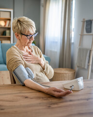 Senior caucasian woman check blood pressure measure device on hand