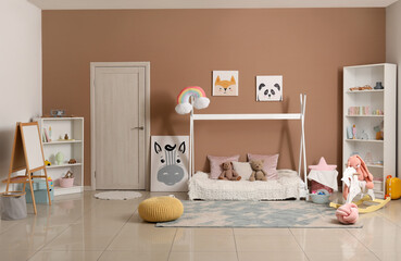 Interior of modern children's room with comfortable bed and shelving unit