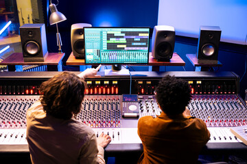 Audio engineer and artist collaborating on new songs for pop album, composing and editing tunes...