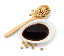 Tasty soy sauce in gravy boat, soybeans and spoon isolated on white, top view
