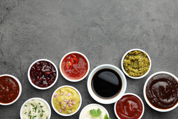 Different tasty sauces in bowls on grey table, flat lay. Space for text