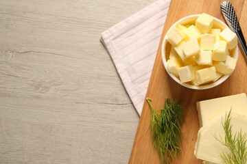Tasty butter with dill and knife on wooden table, top view. Space for text
