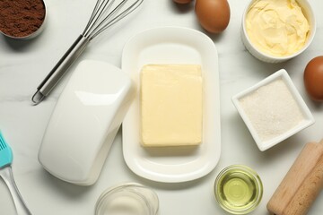 Flat lay composition with fresh butter among other products on white table