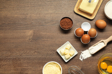 Flat lay composition with fresh butter among other products on wooden table. Space for text