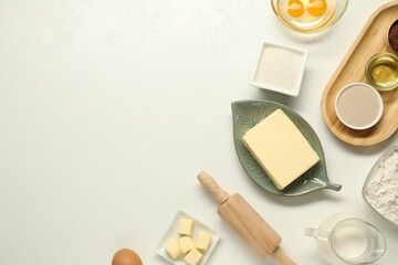 Flat lay composition with fresh butter among other products on white table. Space for text