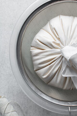 Greek yogurt being strained in white cotton cloth, process of making Greek yogurt, strained yogurt...