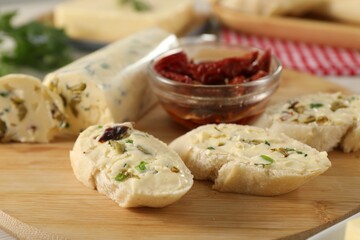 Tasty butter with olives, green onion, chili peppers and bread on table, closeup
