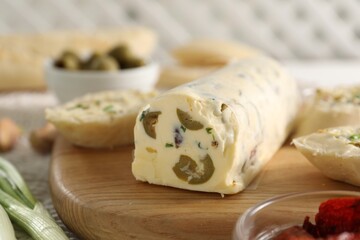 Tasty butter with olives and green onion on table, closeup