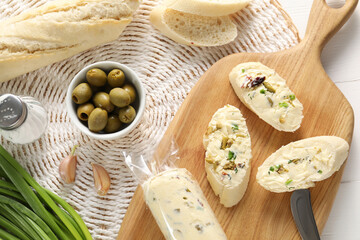 Tasty butter with olives, green onion, garlic and bread on table, top view