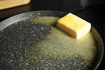 Melting butter in frying pan, closeup view