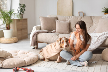 Beautiful young woman with cute fluffy Australian Shepherd dog in living room