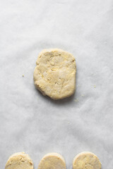 Raw scone dough on a parchment lined baking sheet, process of making scones