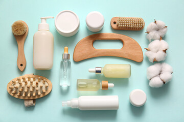 Beautiful spa composition with guasha body scraper on turquoise background