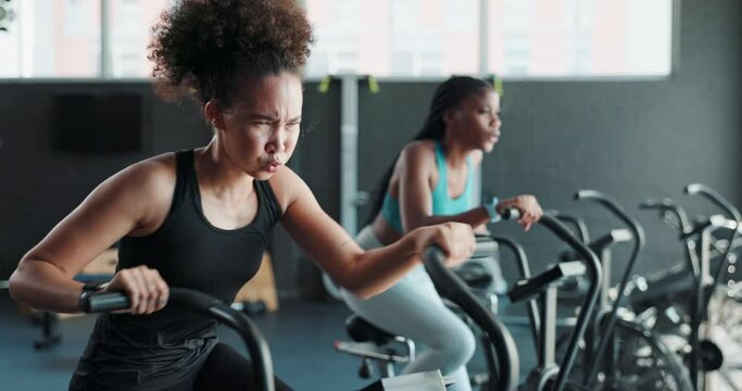 Strong, gym or woman on cycling machine for a tough workout or cardio training for endurance. Fitness class, exercise bike and healthy sports person on bicycle for hard work, challenge or wellness