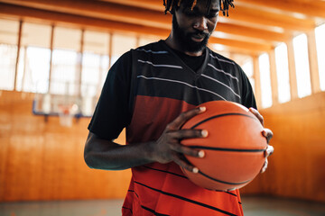 Portrait of an african basketball player with dreadlocks holding a ball