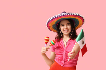 Beautiful young happy woman in sombrero with maracas and Mexican flag on pink background. Cinco de...