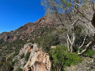 Springtime view of the red rocky mountain landscape in Tonto Natural Bridge State Park in Pine, Arizona with bright blue sky copy space in an area showing the top of the small waterfall above the natu