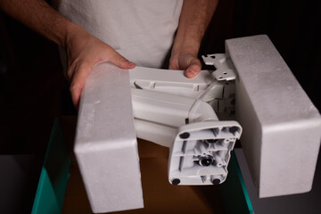 The hands of a young guy installing a computer monitor