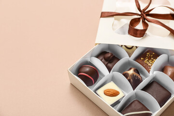 Box with delicious candies on brown background