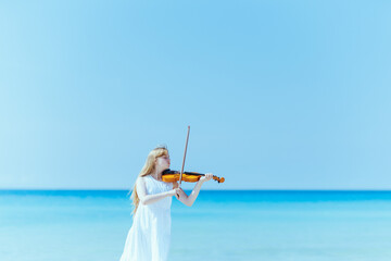 modern teen girl in light dress enjoying playing on seacoast