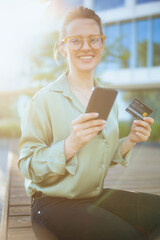 happy business woman in green blouse and eyeglasses using phone