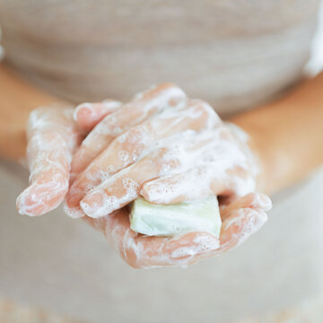 Closeup on young woman hands with soap bar