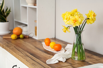 Beautiful bouquet of daffodils in kitchen