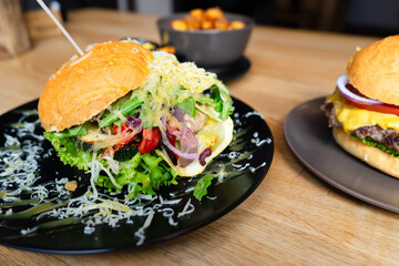 Loaded Gourmet Burger with Fresh Toppings on a Black Plate