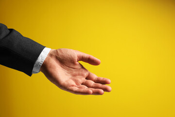 Fototapeta premium Man holding something in hand on yellow background, closeup. Space for text