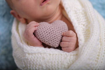 newborn baby holding a hearth cute newborn photo shoot