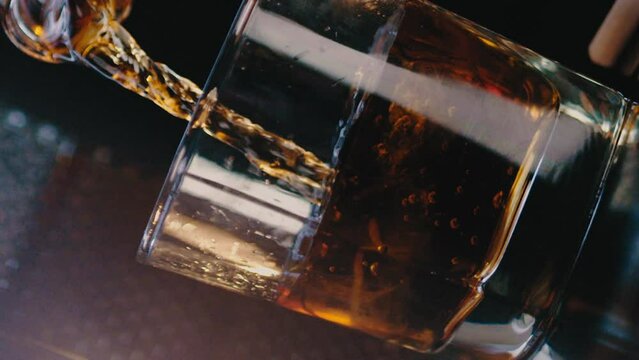 Whiskey being poured into a whiskey glass dutch angle