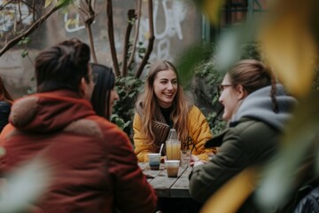 Group of young friends sitting in a cafe, drinking coffee and talking