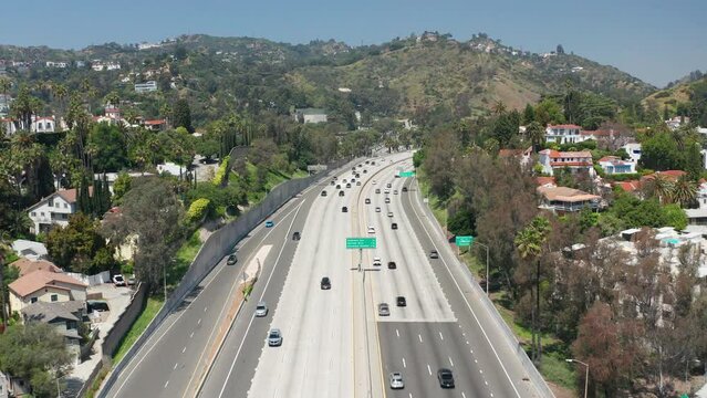 Establish shot of Hollywood Hills, mansions, palm trees, 101 highway car traffic