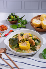 Sayur Lodeh is a vegetable dish made with coconut milk that is typical of Indonesia, especially in Central Java and DI Yogyakarta. Served in a bowl on a white table. Selective focus.