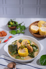 Sayur Lodeh is a vegetable dish made with coconut milk that is typical of Indonesia, especially in Central Java and DI Yogyakarta. Served in a bowl on a white table. Selective focus.