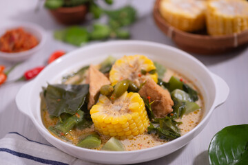 Sayur Lodeh is a vegetable dish made with coconut milk that is typical of Indonesia, especially in Central Java and DI Yogyakarta. Served in a bowl on a white table. Selective focus.