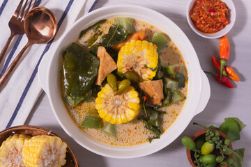 Sayur Lodeh is a vegetable dish made with coconut milk that is typical of Indonesia, especially in Central Java and DI Yogyakarta. Served in a bowl on a white table. Selective focus.