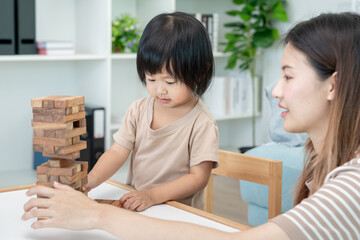 Happy Asia mother play and learn toy blocks with the little girl. Funny family is happy and excited...