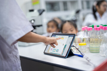 A person is pointing at a tablet on a table