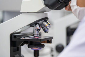 A person is looking through a microscope