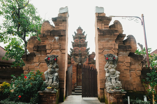 Balinese temple known as "Pura" entrance gate usually known as "Candi Bentar" with two guardian statues flanking the sides called Dwarapala