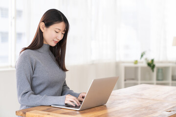 部屋でラップトップコンピューターを見る女性