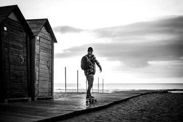 Man with a skateboard towards the beach