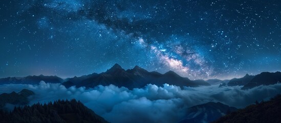 Scenic view of a dark night sky adorned with twinkling stars and wispy clouds hanging above majestic mountains