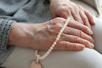 数珠を持つ高齢女性の手元