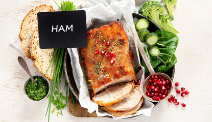 Sliced baked ham with salad on light wooden background. Traditional food concept