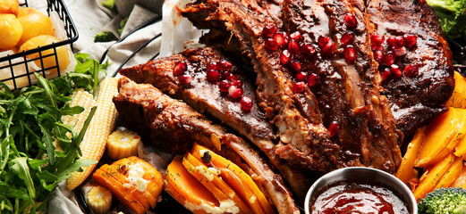 Pork ribs with vegetables on black background. Food for picnic concept