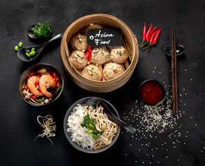 Chinese hot food. Dumplings, soy sauce, shrimp on black background. Traditional asian lunch