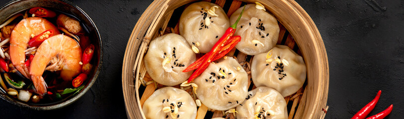 Chinese hot food. Dumplings, soy sauce, shrimp on black background. Traditional asian lunch